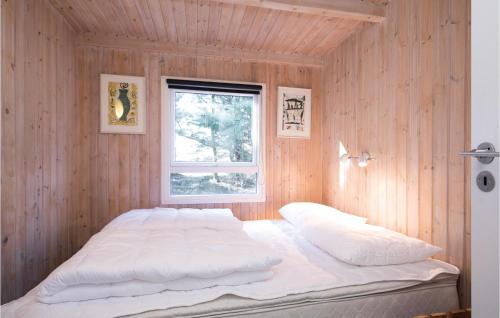ロンストラップにある3 Bedroom Beautiful Home In Hjrringの木製の壁に白い大型ベッドが備わるベッドルーム1室