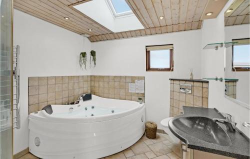 ノーポにある3 Bedroom Amazing Home In Nordborgのバスルーム(大きな白いバスタブ、シンク付)
