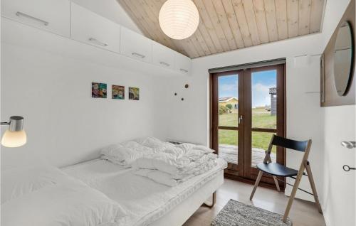 ノーポにある3 Bedroom Amazing Home In Nordborgのベッドルーム1室(ベッド1台、椅子、窓付)