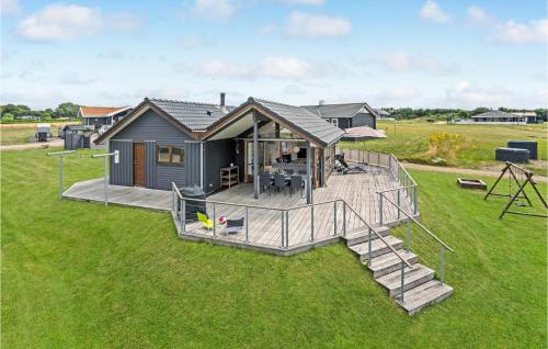 a tiny house with a deck and a playground at Holiday Home Vinkelbæk Dnmkt in Nordborg