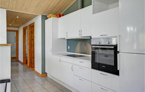 a kitchen with white cabinets and a stove top oven at Lovely Home In Knebel With Sauna in Skødshoved Strand