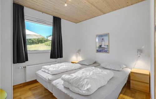 two beds in a white room with a window at Amazing Home In Knebel With Private Swimming Pool, Can Be Inside Or Outside in Skødshoved Strand