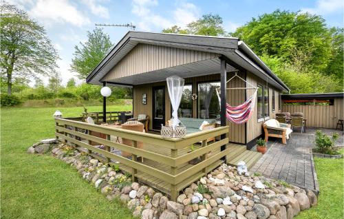 a small cabin with a deck and a patio at Beautiful Home In Haarby With Kitchen in Brunshuse