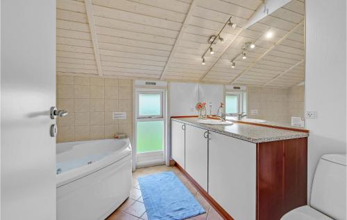 ein Badezimmer mit einer Badewanne, einem Waschbecken und einem WC in der Unterkunft 4 Bedroom Nice Home In Sklskr in Skælskør