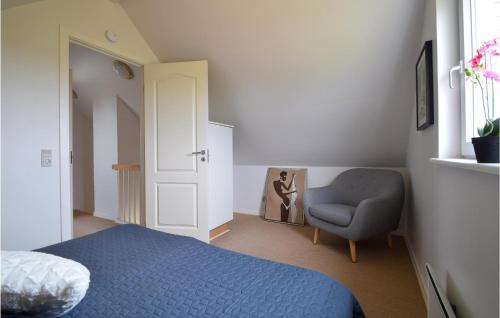 a bedroom with a blue bed and a chair at Holiday Home Strandg in Bro