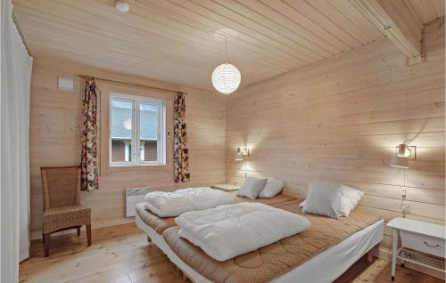 1 dormitorio con 2 camas en una habitación con paredes de madera en 3 Bedroom Nice Home In Hjslev, en Højslev