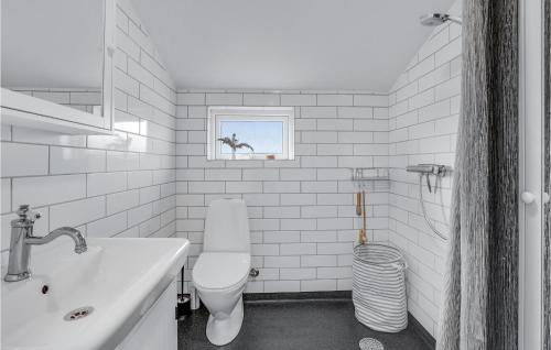 uma casa de banho branca com um WC e um lavatório em 3 Bedroom Stunning Home In lbk em Ålbæk