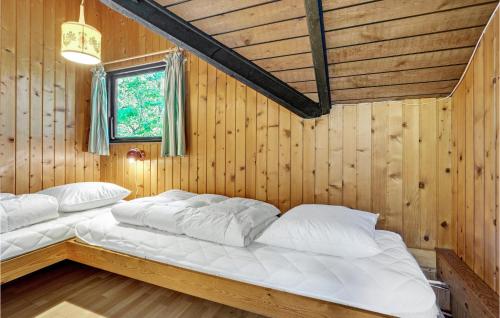 HelberskovにあるStunning Home In Hadsund With 3 Bedrooms And Wifiの木製の部屋にベッド2台が備わるベッドルーム1室