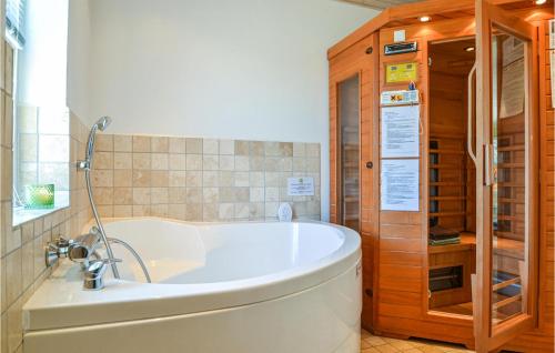 una vasca da bagno seduta in un bagno accanto a una finestra di Two-Bedroom Holiday Home In Hvide Sande a Hvide Sande