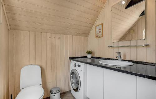 y baño con lavadora y lavamanos. en Awesome Home In Blvand With Sauna, en Blåvand