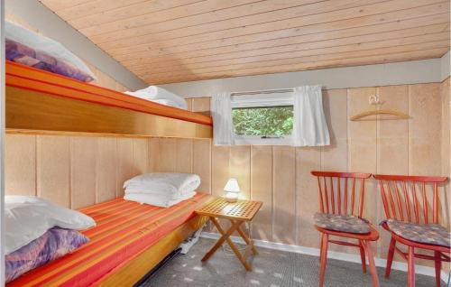 Glesborgにある3 Bedroom Cozy Home In Glesborgのベッド、テーブル、椅子が備わる小さな客室です。