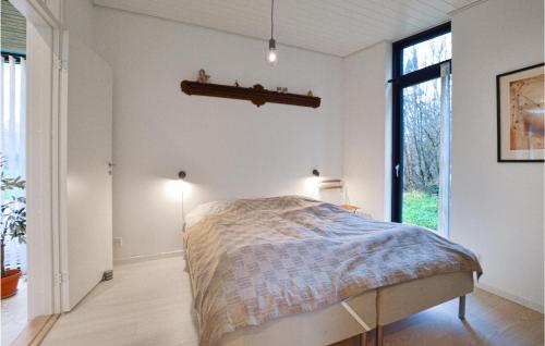 1 dormitorio con 1 cama en una habitación con ventana en 5 Bedroom Nice Home In Rrvig, en Rørvig