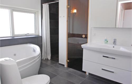 a bathroom with a white toilet and a sink at Lovely Home In Haderslev With Wifi in Årøsund