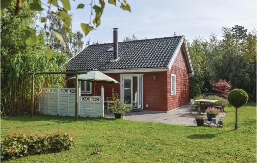 a small red house with a picnic table in a yard at One-Bedroom Holiday Home In Kalundborg in Kalundborg