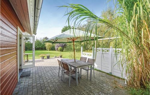 a table and chairs with an umbrella on a patio at One-Bedroom Holiday Home In Kalundborg in Kalundborg
