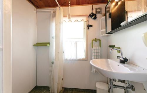 a bathroom with a sink and a toilet and a window at Awesome Home In Nex With 2 Bedrooms And Wifi in Bedegård