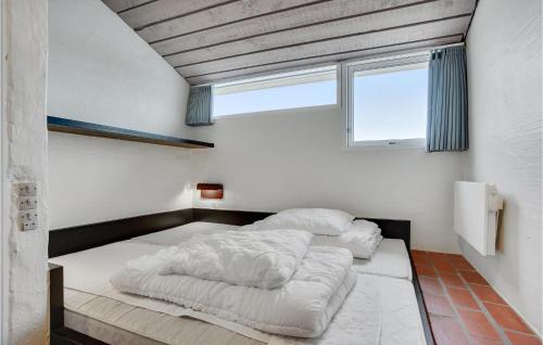 Feriehotel Tranum Klit في Brovst: سريرين في غرفة مع نافذة