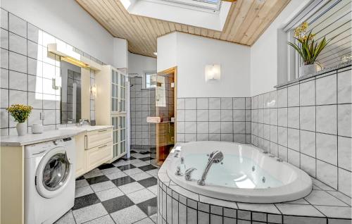 La salle de bains est pourvue d'une baignoire et d'un lave-linge. dans l'établissement Amazing Home In Knebel With Wifi, à Knebel