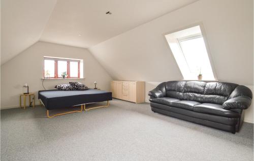 a living room with a leather couch and a bed at Three-Bedroom Holiday Home In Store Heddinge in Store Heddinge