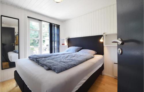 um quarto com uma cama grande e uma cabeceira preta em 3 Bedroom Beautiful Home In Juelsminde em Juelsminde