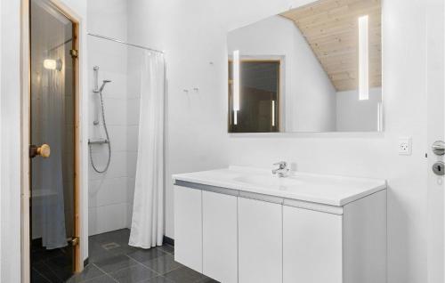 Baño blanco con lavabo y espejo en Beautiful Home In Rdby With Wifi, en Kramnitse