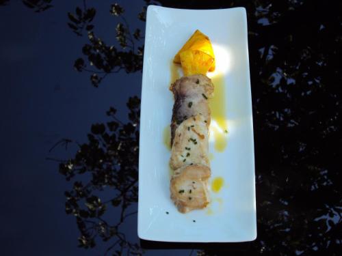 a piece of sushi on a white plate with an orange on it at Hotel Casa Peix in Serraduy