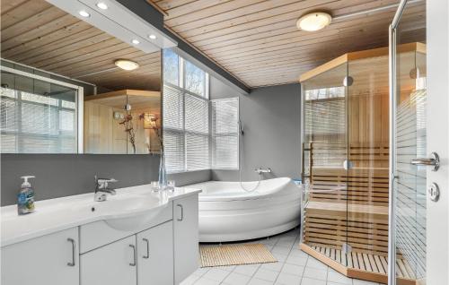 a bathroom with a tub and a sink and a bath tub at Beautiful Home In Hasle With Sauna in Tofte