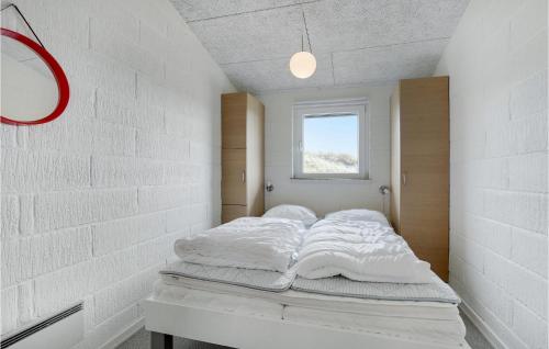 a bedroom with a bed with white sheets and a window at Nice Home In Hvide Sande With Kitchen in Havrvig