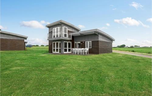 a small house on a grassy field with a table at Awesome Home In Faaborg With Sauna in Åstrup