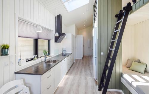 una cocina con armarios blancos y una escalera en Lovely Home In Juelsminde With House Sea View, en Sønderby