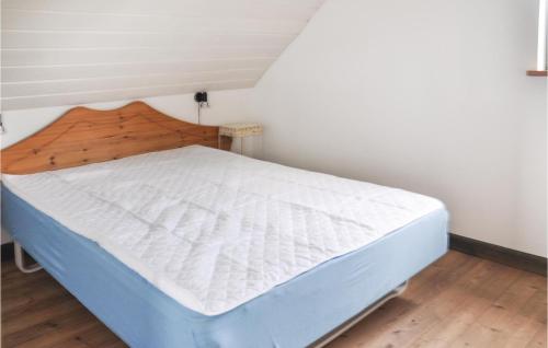 Schlafzimmer mit einem Bett mit einem Kopfteil aus Holz in der Unterkunft Gorgeous Home In Faaborg With Sauna in Fåborg