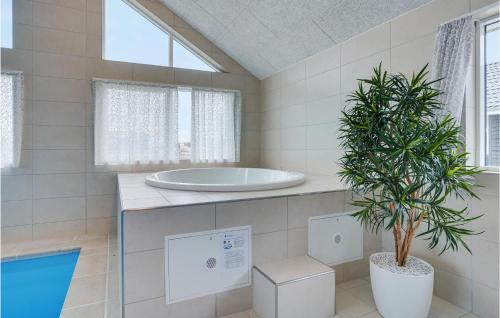 een badkamer met een bad en een potplant bij Pet Friendly Home In Sydals With Indoor Swimming Pool in Sarup