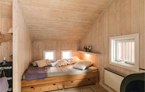 SnogebækにあるAmazing Home In Nex With 3 Bedrooms, Sauna And Wifiの木製の壁の部屋の角にあるベッド