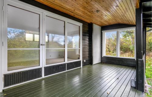 een afgeschermde veranda met ramen en een houten plafond bij 2 Bedroom Stunning Home In Slagelse in Slagelse