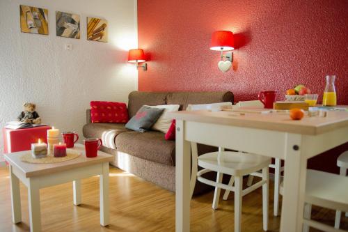 uma sala de estar com um sofá e uma mesa em VVF La Plagne Montchavin Paradiski em Bellentre