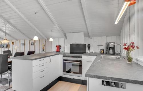 a kitchen with white cabinets and a counter top at Holiday Home Gøgevej Dronningmølle Vi in Dronningmølle