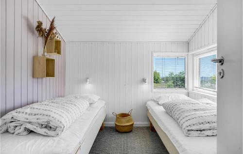 two beds in a room with white walls and a window at Cozy Home In Knebel With House Sea View in Knebel