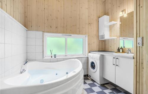 a bathroom with a tub and a sink and a washing machine at Cozy Home In Knebel With House Sea View in Knebel