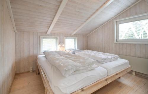 エーベルトフトにあるAmazing Home In Ebeltoft With Saunaの窓2つが備わる客室で、白い大型ベッド1台が付いています。