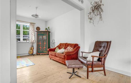 een woonkamer met een bank en een stoel bij Gorgeous Home In stermarie With Kitchen in Østermarie