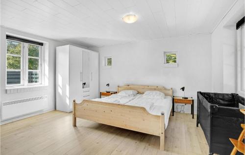 a bedroom with a wooden bed in a room at Awesome Home In Toftlund With Kitchen in Arrild