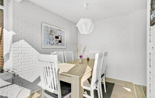 a dining room with a wooden table and white walls at Holiday Home Østmarken Toftlund V in Arrild