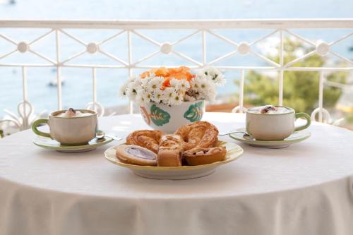 
a table topped with a plate of donuts and a cup of coffee at Villa La Tartana in Positano
