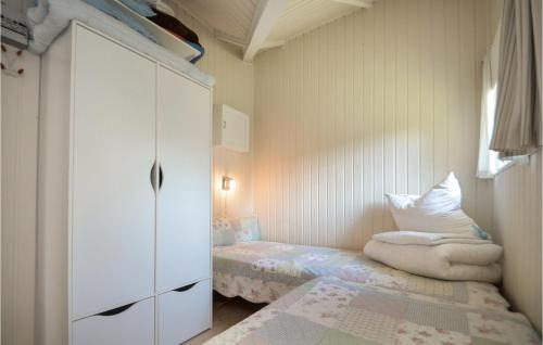 um quarto com uma cama, um armário branco e um banco em Nice Home In Vggerlse With Wifi em Bøtø By