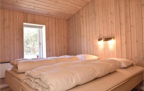 duże łóżko w pokoju z drewnianymi ścianami w obiekcie 3 Bedroom Stunning Home In Herning w mieście Herning