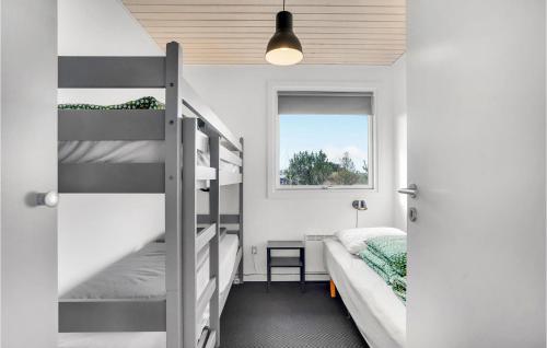 Bjerregårdにある3 Bedroom Cozy Home In Hvide Sandeのベッドルーム1室(二段ベッド2台、窓付)が備わります。