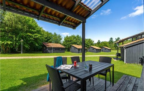 a wooden table and chairs on a patio at 1 Bedroom Awesome Home In Hampen in Hampen