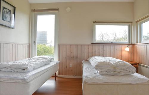 two beds in a room with two windows at Nice Home In Skjern With Wifi in Lem