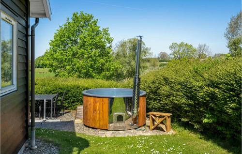 a hot tub in a yard next to a house at Holiday Home Træløbervej Tranekær Xi in Lokkeby