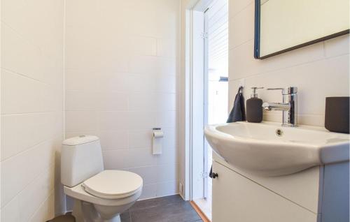 a white bathroom with a toilet and a sink at Nice Home In Frrup With Kitchen in Frørup